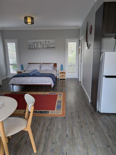a bedroom with a bed and a table and a kitchen at Southern Comfort in Goolwa North