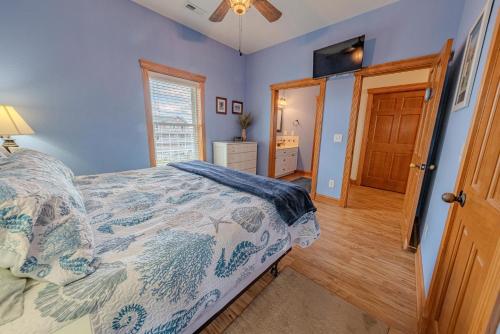 a bedroom with blue walls and a bed and a window at Frolic Inn OBX - Semi Soundfront Retreat, Pool, Hot Tub, Boat Ramp, Elevator, Media & Game Room in Rodanthe