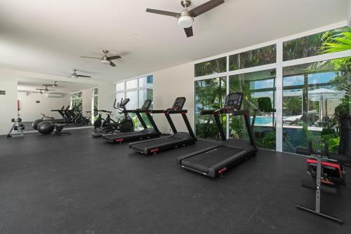 a gym with a row of treadmills and exercise bikes at Akumal Seabreeze Private Hot Tub Beach Access 11 Pools in Akumal