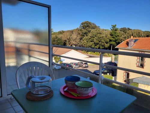 - une table avec deux tasses sur un balcon avec vue dans l'établissement Appartement T2 avec balcon, à 100m de la plage et proche des commerces à Saint-Brevin-les-Pins - FR-1-364-93, à Saint-Brévin-les-Pins
