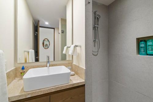 a bathroom with a white sink and a shower at Akumal Seabreeze Private Hot Tub Beach Access 11 Pools in Akumal