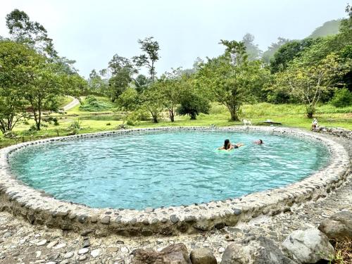 a person swimming in a pool of water at Casa Lajas - Casa 1 - Hospedaje, Granja y Turismo Rural in Turrialba