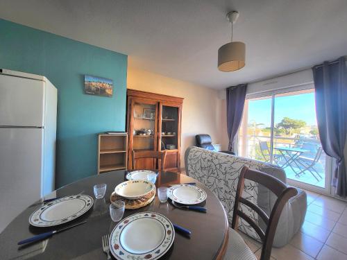 - un salon avec une table à manger et un réfrigérateur dans l'établissement Appartement 2 pers à St Brevin les Pins, 50m plage, balcon, parking, proche commerces - FR-1-364-163, à Saint-Brévin-les-Pins
