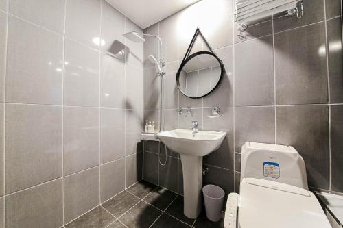 a bathroom with a sink and a toilet and a mirror at Fine Avenue Hotel in Changwon