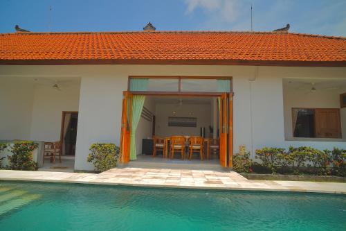 a house with a swimming pool next to a house at Villa Seruni Lovina in Lovina