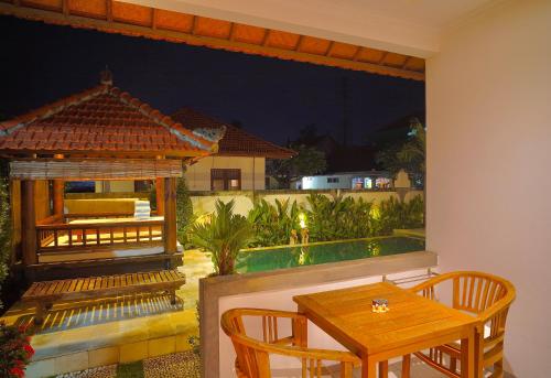 a patio with a table and chairs and a pool at Villa Seruni Lovina in Lovina