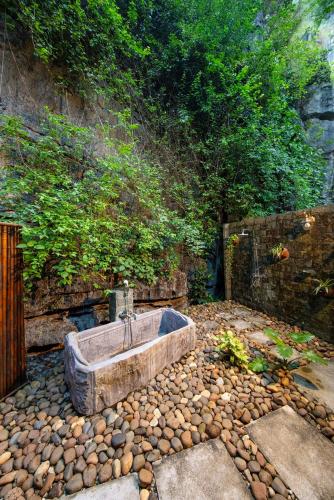 a bath tub sitting on top of a pile of rocks at Hang Mua Ecolodge in Ninh Binh