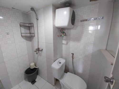 une salle de bains blanche avec des toilettes et une poubelle dans l'établissement Raja Apartemen Jarrdin Type 33, à Bandung