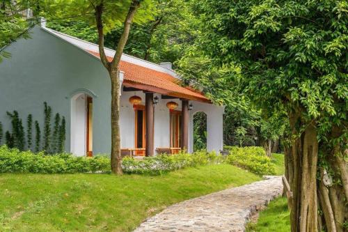 a small white house with an orange roof at Hang Mua Ecolodge in Ninh Binh
