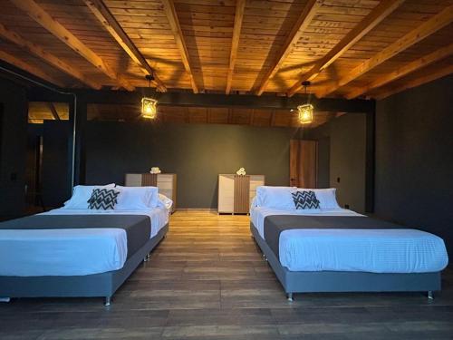 グアタペにあるGRETEL CHALETS SUIZOの木製天井の客室で、ベッド2台が備わります。
