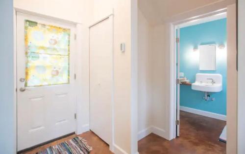 a bathroom with a white door and a sink at Cozy Alley Cottage, Concordia, Alberta Arts, NE PDX in Portland