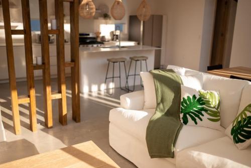 ein Wohnzimmer mit einer weißen Couch und einer Küche in der Unterkunft Malamala West Bay in West Bay