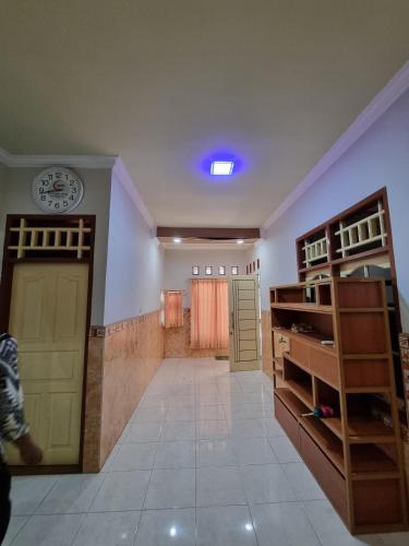 a room with a door and a clock on the wall at Amira Homestay Mataram in Tjakranegara
