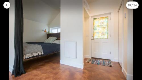 a small bedroom with a bed and a window at Cozy Alley Cottage, Concordia, Alberta Arts, NE PDX in Portland