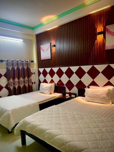 a hotel room with two beds in a room at Bảo Huy Hotel Tam Kỳ in Tam Ky