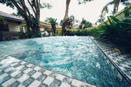 a swimming pool with blue water in a yard at Grand Villa Laguna in Manila