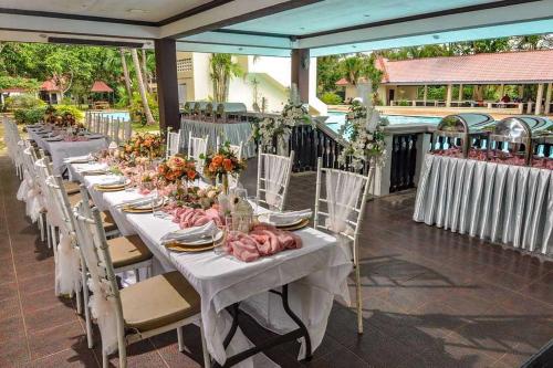 a row of tables with flowers on top at Grand Villa Laguna in Manila
