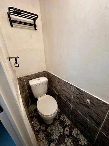 a bathroom with a white toilet in a room at Bgs Place Moalboal in Moalboal