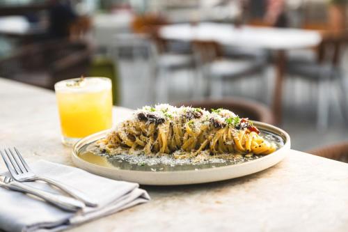 a plate of food on a table with a drink at Viceroy Santa Monica in Los Angeles