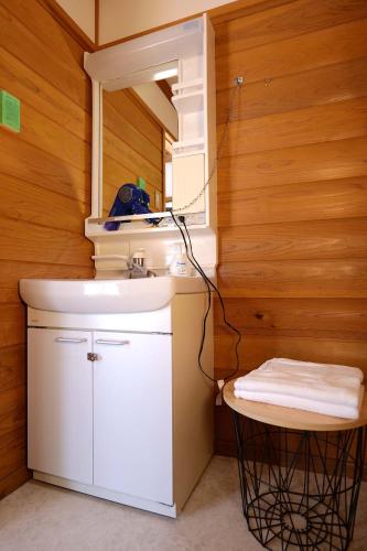 a bathroom with a sink and a mirror and a stool at 閑乗寺JoyBase in Nanto