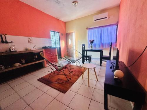 a living room with red walls and a table and chairs at Comfortable estancia in Palenque