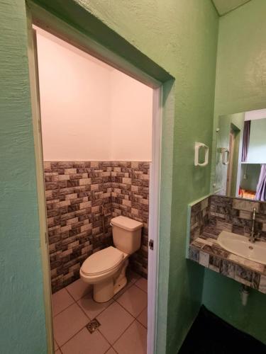 a bathroom with a toilet and a sink at Kobe's Beachfront Haven in Siquijor