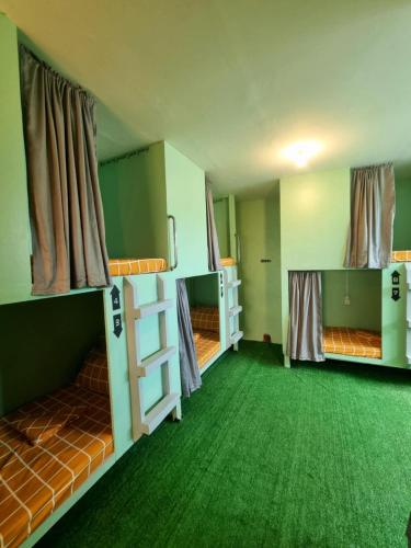 two bunk beds in a room with green carpet at Kobe's Beachfront Haven in Siquijor