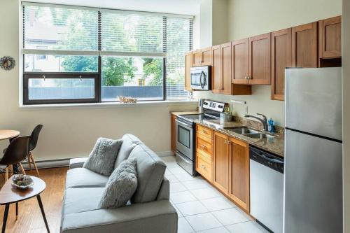 ハリファックスにあるQuaint Loft with AC Abundance of Sunlight, Unit #4のソファとキッチンのあるリビングルーム