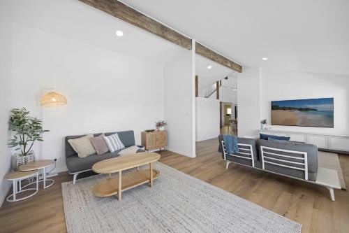 un soggiorno con un divano e un tavolo di Deja Bleu - great family home with jetty a Port Macquarie