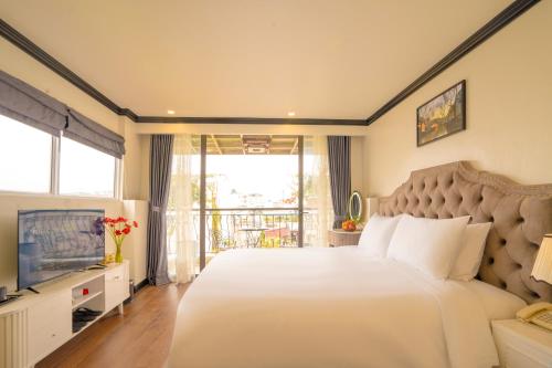 una camera da letto con un letto grande e una televisione di Hotel Du Palace a Hanoi