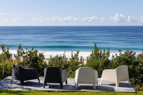 four chairs sitting on a table near the beach at Salt Rock Boomerang Beach in Boomerang Beach
