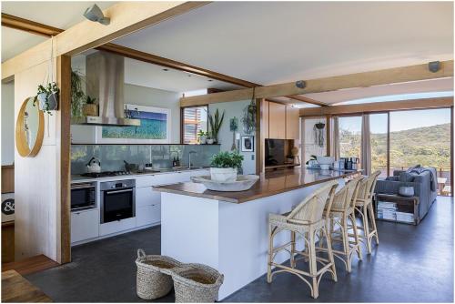 a kitchen with a counter and chairs in a room at Salt Rock Boomerang Beach in Boomerang Beach