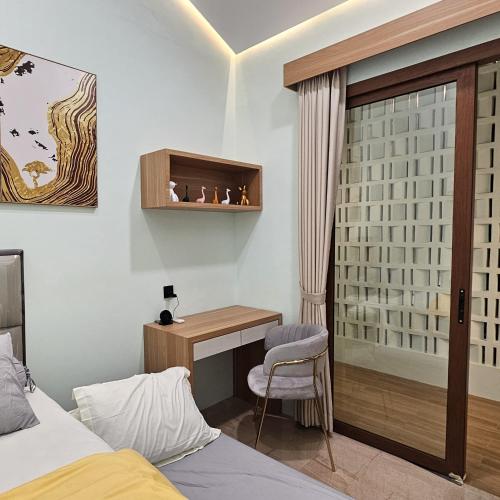 a bedroom with a desk and a bed and a chair at 3 Bedroom House Near Grand Batam Mall in Bagam