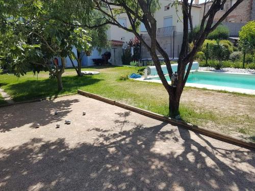une cour avec une piscine et un arbre dans l'établissement Maison, Piscine, à Rivesaltes