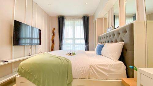 ein Schlafzimmer mit einem großen Bett und einem Fernseher in der Unterkunft Fancy and Nice 1BR at Citralake Suites Apartment By Travelio in Jakarta