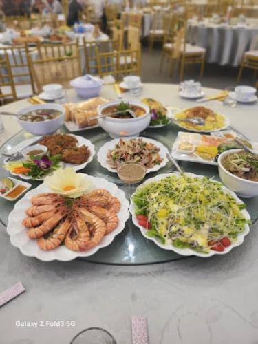 a table with many plates of food on it at Crown Hotel in Thái Nguyên