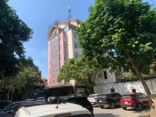 a tall building with cars parked in a parking lot at Crown Hotel in Thái Nguyên