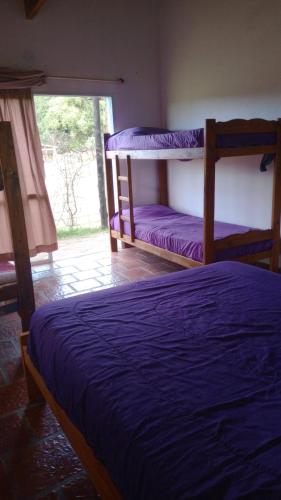 a bedroom with two bunk beds and a window at Cabañas Sol de las Sierras in Tandil