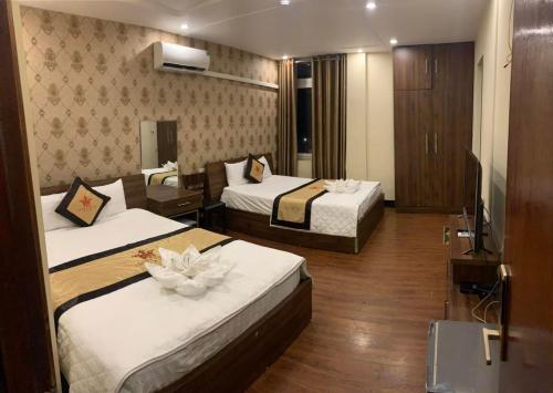 a hotel room with two beds with flowers on them at Crown Hotel in Thái Nguyên