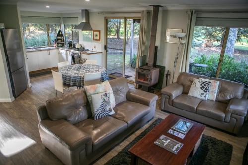 a living room with couches and a table and a kitchen at Bettenays Margaret River in Metricup