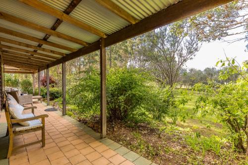 a porch with a wooden roof and chairs on it at Bettenays Margaret River in Metricup