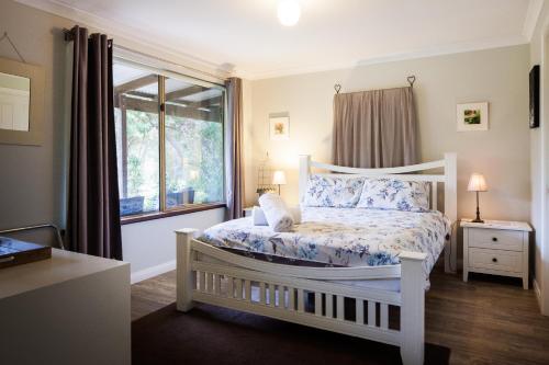 a bedroom with a white bed and a window at Bettenays Margaret River in Metricup