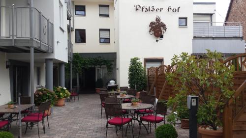 a patio with tables and chairs and a building at Hotel-Restaurant Pfälzer Hof in Edenkoben