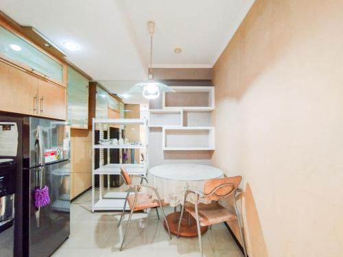 a kitchen with a table and chairs in a room at Amazing 1BR Apartment Gateway Pasteur By Travelio in Bandung