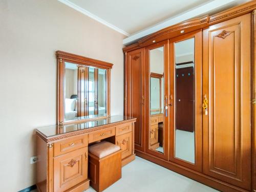 a bathroom with a wooden vanity and a mirror at Amazing 1BR Apartment Gateway Pasteur By Travelio in Bandung