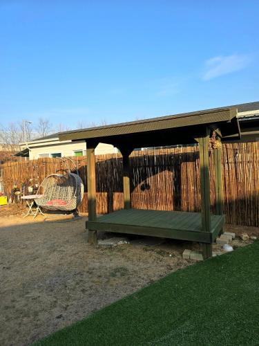 a wooden pavilion with a bench in a yard at Detached house with a large yard, 15 minutes from the sea in Hwaseong in Hwaseong
