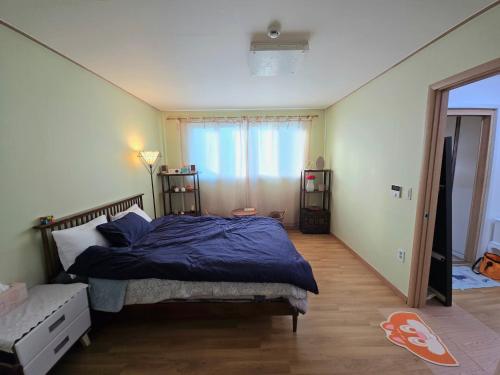 a bedroom with a bed with a blue comforter at Detached house with a large yard, 15 minutes from the sea in Hwaseong in Hwaseong