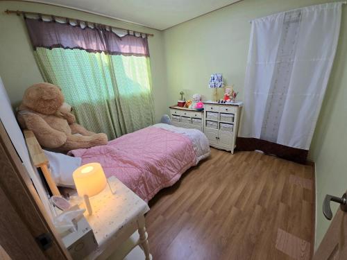 a small bedroom with a bed and a teddy bear at Detached house with a large yard, 15 minutes from the sea in Hwaseong in Hwaseong