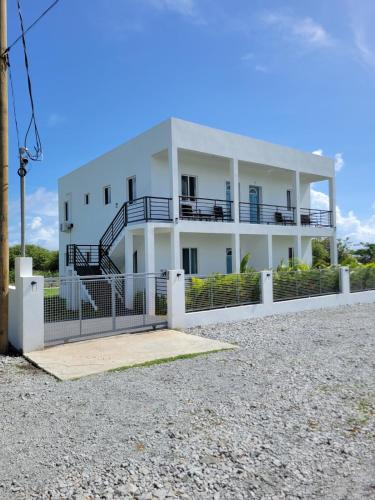 a white house with a staircase in front of it at Luxury Rental Apartment in Brown Hill, Nevis in Nevis