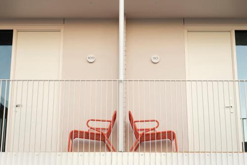 two red chairs sitting next to a fence at Kar-Rama Hotel in Mildura
